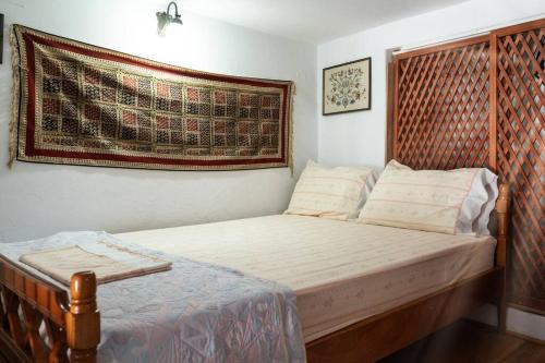 a bedroom with a bed with a wooden headboard at Το παραδοσιακό σπίτι του Φτούλη! in Skiros