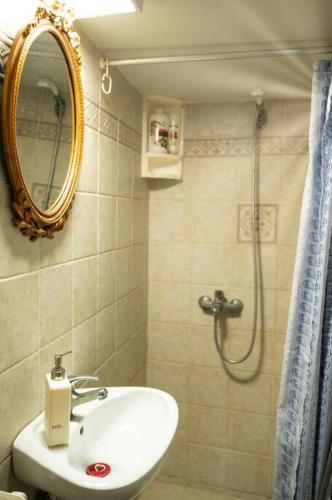 a bathroom with a sink and a shower with a mirror at Το παραδοσιακό σπίτι του Φτούλη! in Skiros