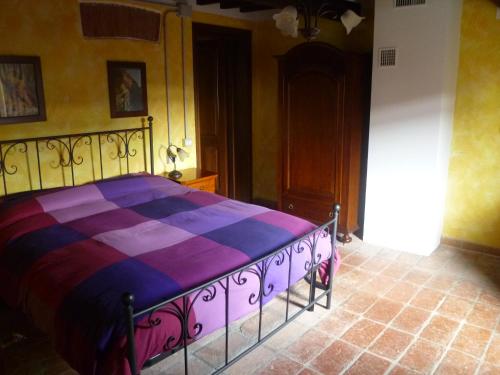1 dormitorio con 1 cama con edredón morado y morado en Casolare Fratina, 
