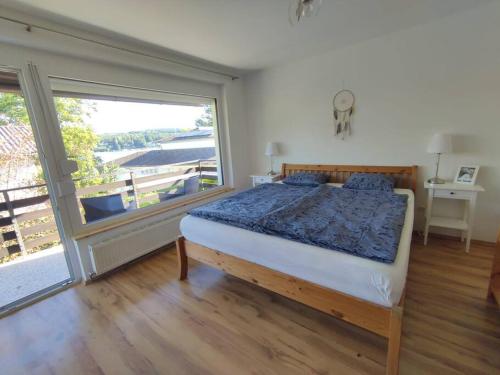 een slaapkamer met een bed en een groot raam bij Appartement am See in Velden in Velden am Wörthersee
