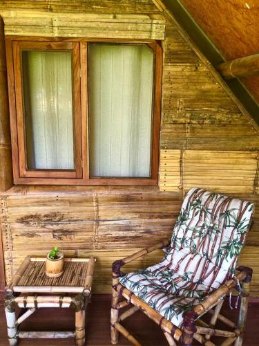 a rocking chair and a table in a cabin at Sitio Simple Life in Ubatuba