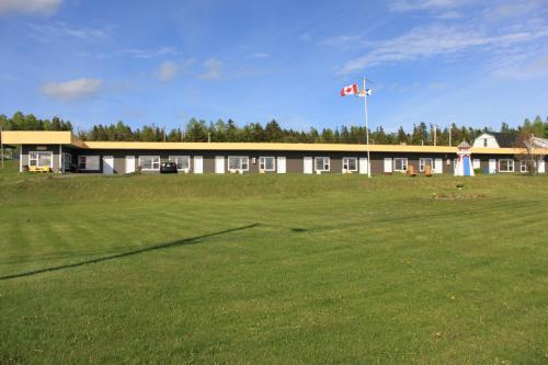 a large building with a flag in front of a field at Oasis Motel in Antigonish
