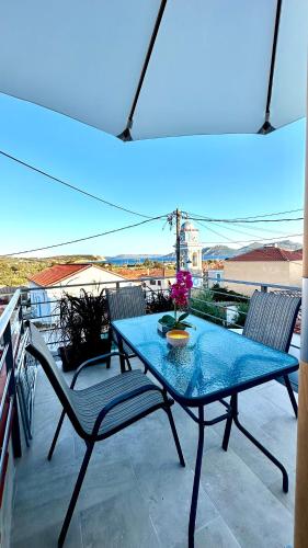 a table and chairs on a balcony with a blue light at Saint Nicolas luxury apartment in Methoni