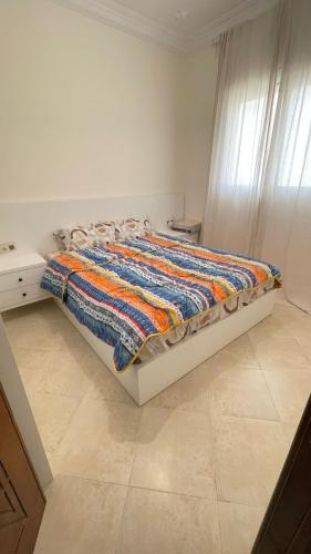 uma cama com um cobertor colorido num quarto em tetouan wilaya em Tétouan