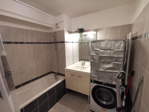 La salle de bains est pourvue d'un lave-linge et d'un lavabo. dans l'établissement Magnifique appartement pour 8 personnes à Montpellier - WIFI/PARKING, à Montpellier