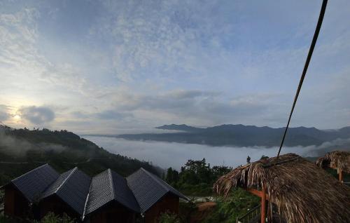 a group of huts on a hill with a view of a valley at Homestay Chân Mây Chiêu Lầu Thi in Hoàng Su Phì