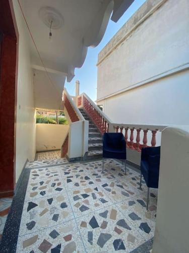 a room with a staircase with chairs and a tiled floor at Calm Coast Villa in Agaouz