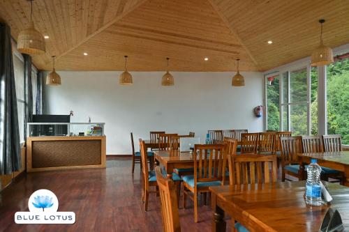 a dining room with wooden tables and chairs at Blue Lotus by M - Resort and Camps in Mukteswar
