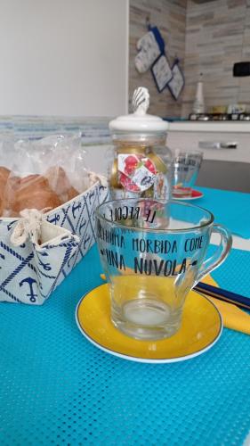 Un vaso de vidrio sobre un plato amarillo sobre una mesa. en GATTI e MARE, en Salerno