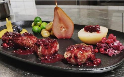 a plate of food with fruit on a table at Hotel de ville d'Yvonand in Yvonand