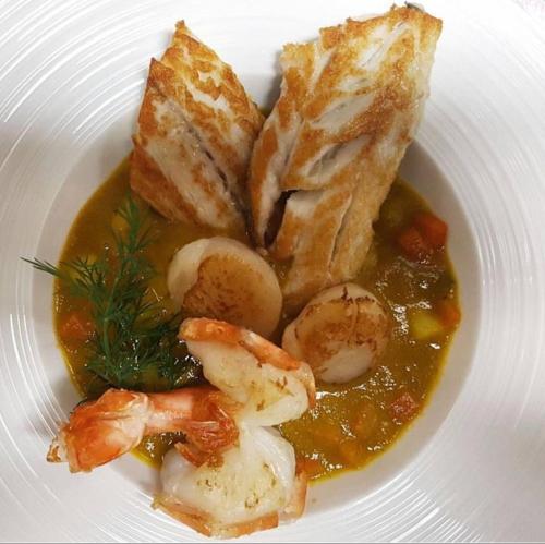 a plate of food with shrimp and bread on it at Hotel de ville d'Yvonand in Yvonand