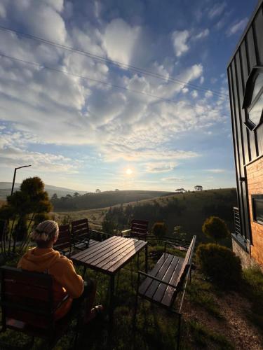 a man sitting on a bench looking at the view at Zlatibor Wild nest Rabbit Lux in Zlatibor