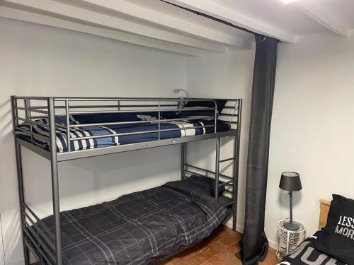 a bedroom with two bunk beds in a room at Gîte La Baz en centre-ville d'un village du Perche - La Bazoche-Gouet in La Bazoche-Gouet