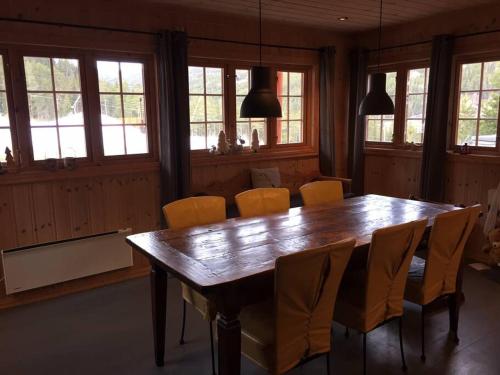 ein Esszimmer mit einem Holztisch und Stühlen in der Unterkunft Bjørnehuset in Sønstebø