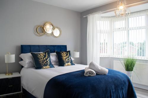 a bedroom with a large bed with a blue blanket at Stunning 5 Bed Detached Home Nottingham in Nottingham