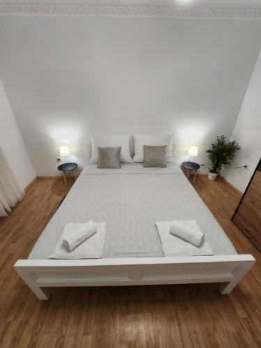 a white bed in a white room with two lamps at Cvet - Sobe in Bela Crkva