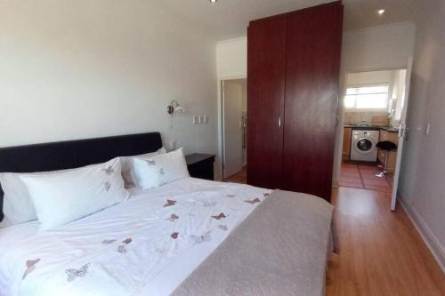 a bedroom with a large white bed with flowers on it at Golf Estate apartment close to the Beach in Cape Town