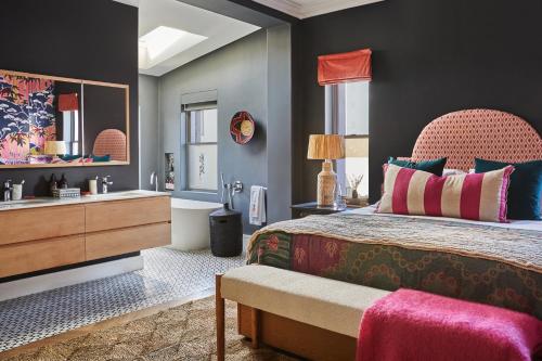 a bedroom with a large bed and a mirror at Pineapple House Boutique Hotel in Cape Town