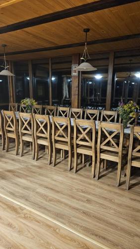 a row of chairs and a table in a restaurant at Leśna Osada Szegdy in Szegdy