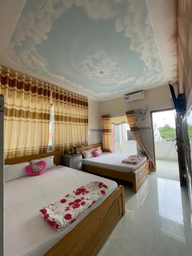 - une chambre avec deux lits et un plafond dans l'établissement My Linh Motel 976 Đường võ thị sáu long hải, à Long Hải
