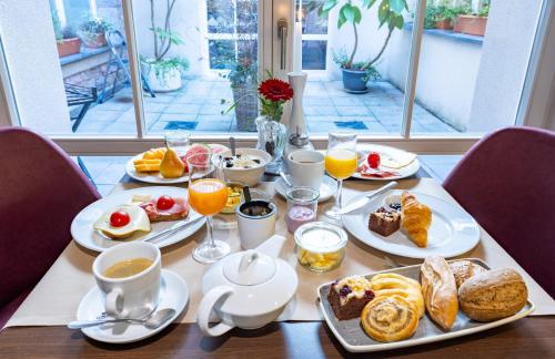 einen Tisch mit Speisen zum Frühstück und Kaffee in der Unterkunft Batschari Palais Baden-Baden in Baden-Baden
