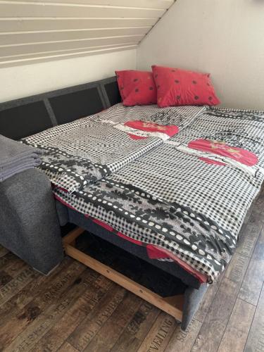 - un lit avec des oreillers rouges et une couverture dans l'établissement Overnatning tæt på Silkeborg, à Engesvang