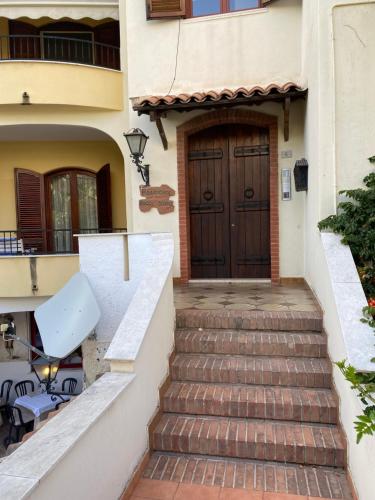 a set of stairs leading to a house with a door at Le Ancorette in Giardini Naxos