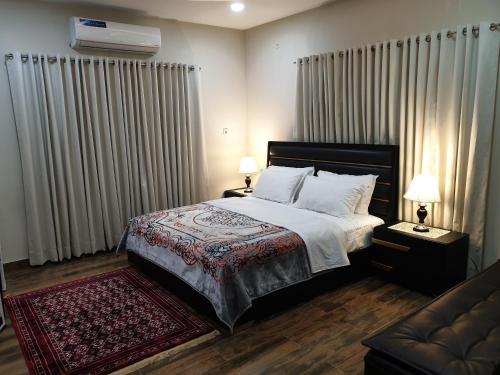 a bedroom with a bed and a couch at Alpha Guest House in Rawalpindi
