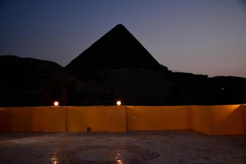 a view of a pyramid and a fence at night at Crystal pyramid inn in Cairo