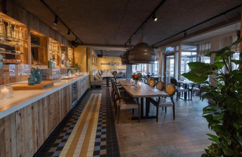 una sala da pranzo con un lungo tavolo e sedie di Appartementen Hotel Meyer a Bergen aan Zee