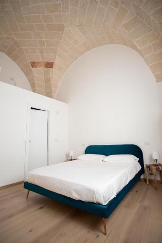 a bedroom with a large bed with a blue frame at Ca’ Lezet in Guagnano