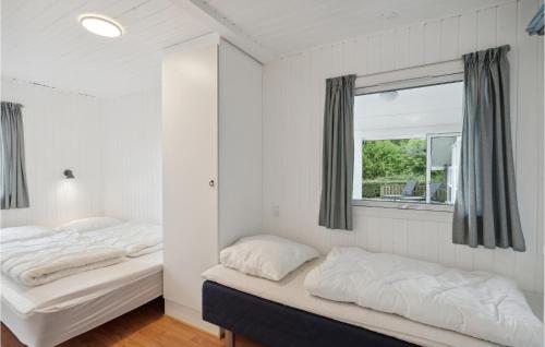 twee bedden in een kamer met een raam bij Awesome Home In Fars With Sauna in Farsø