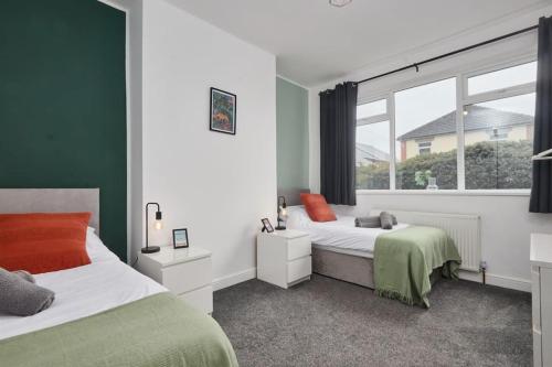 a bedroom with two beds and a window at Haw Hill House - modern 4 bed in Normanton