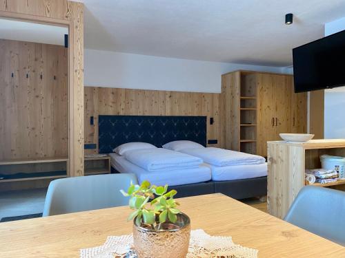 a room with two beds and a table and chairs at Ciasa La Rösa in Badia