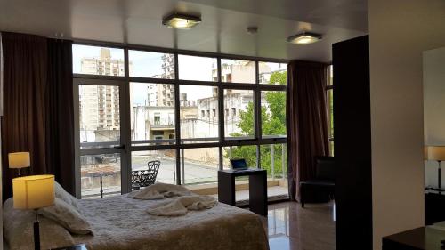 sypialnia z łóżkiem i dużym oknem w obiekcie Hotel del Sol w mieście La Plata