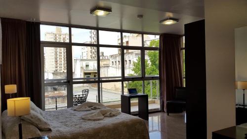 a bedroom with a bed and a large window at Hotel del Sol in La Plata