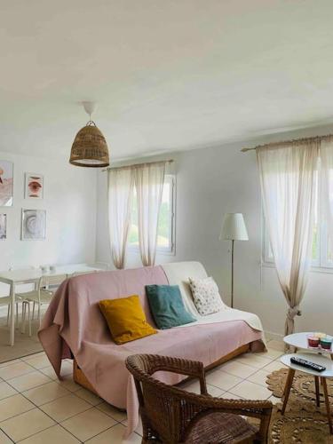 - un salon avec un canapé et des oreillers colorés dans l'établissement Appartement T3 Tarnos cosy proche de la plage, à Tarnos