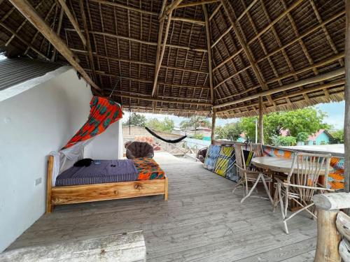 a bedroom with a bed and a hammock on a deck at Villa64 - Afrikanische Villa mit Pool in Nungwi