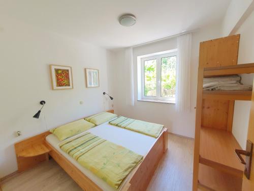 a small bedroom with a bed and a window at Apartments Mostak in Baška