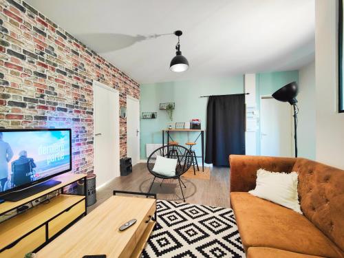 a living room with a couch and a brick wall at 2 Apparts, Riom, 8 pers in Riom