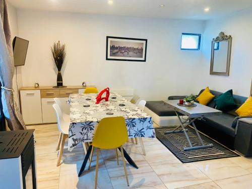 a living room with a table and a couch at Duplex climatisé avec une terrasse sur jardin in Montmorency