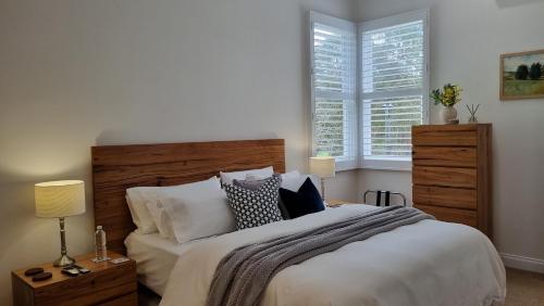 a bedroom with a large bed and a window at Peppercorn Cottage at Treetops Red Hill in Red Hill