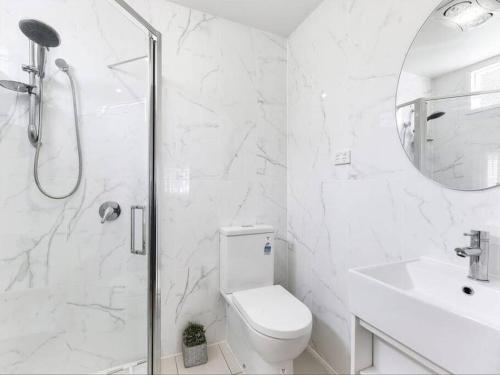 y baño con ducha, aseo y lavamanos. en 4B2B Retreat with parking - 4km to Brisbane CBD, en Brisbane