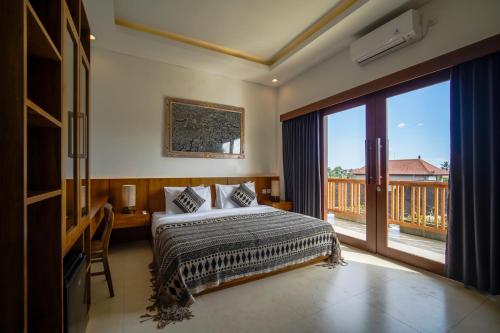 a bedroom with a bed and a balcony at Wakasuta House in Ubud