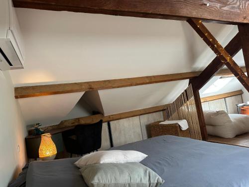 - une chambre mansardée avec un lit bleu dans l'établissement Villa Les Roses, à Marseille