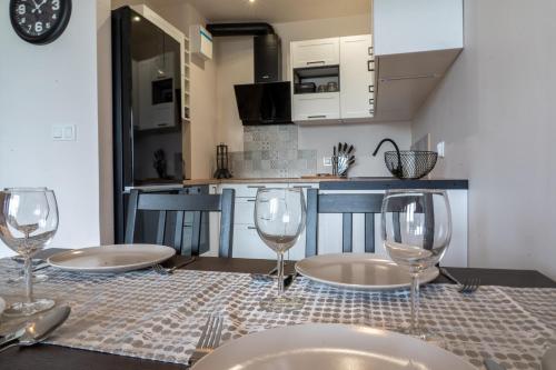 a table with two plates and wine glasses on it at Komfortowy Apartament Nadbrzeżna blisko Warszawy z Parkingiem in Ożarów Mazowiecki