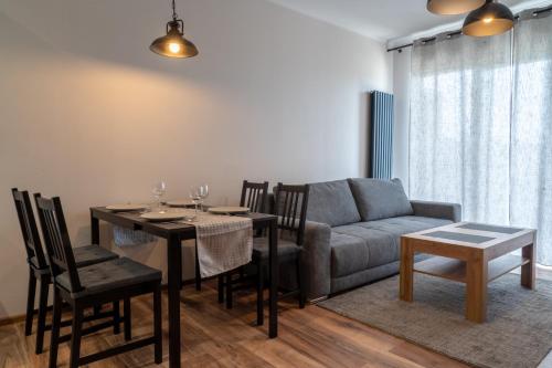 a living room with a table and a couch at Komfortowy Apartament Nadbrzeżna blisko Warszawy z Parkingiem in Ożarów Mazowiecki