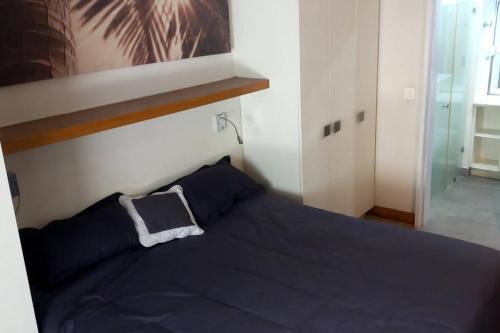 Un dormitorio con una cama azul y una ventana en Beachfront 2 Bedroom Apartment en Bain Boeuf