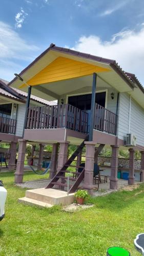 una casa con una gran terraza a un lado en Dusun Rimbun Agro Farmstay, en Kuala Kerai