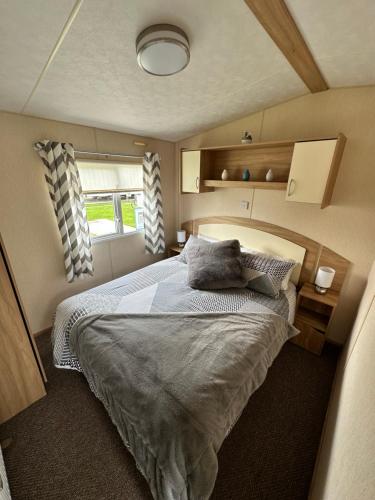 um quarto com uma cama num pequeno quarto em 6 berth caravan on Marine holiday park em Rhyl